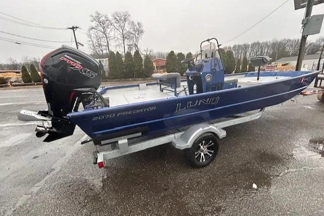 Slide: The Image of 2024 Lund 2070 Predator CC boat on trailer, featuring a powerful outboard motor. - 4