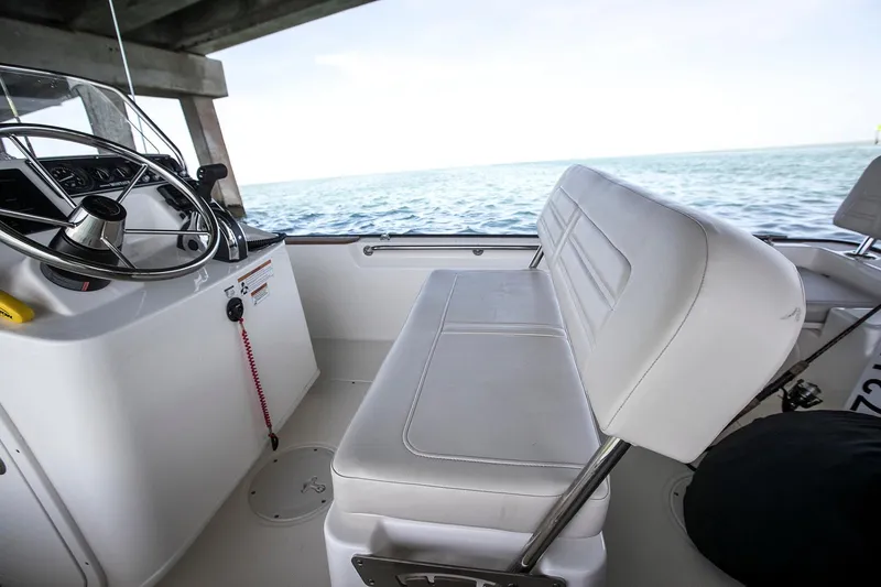 Slide: The Image of Manufacturer Provided Image: 2026 Boston Whaler 170 Montauk boat interior with steering wheel and seating, overlooking the ocean. - 19