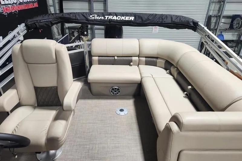 Slide: The Image of 2025 Sun Tracker Party Barge 20 DLX interior with beige seating and steering chair. - 11