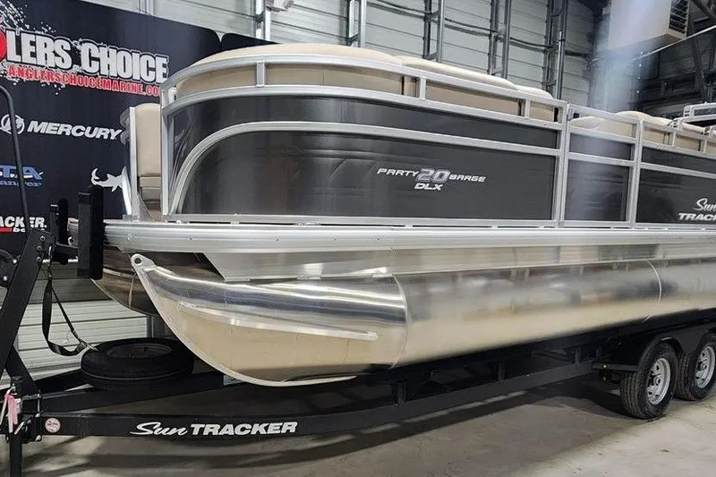 Slide: The Image of 2025 Sun Tracker Party Barge 20 DLX pontoon boat on trailer in showroom. - 9