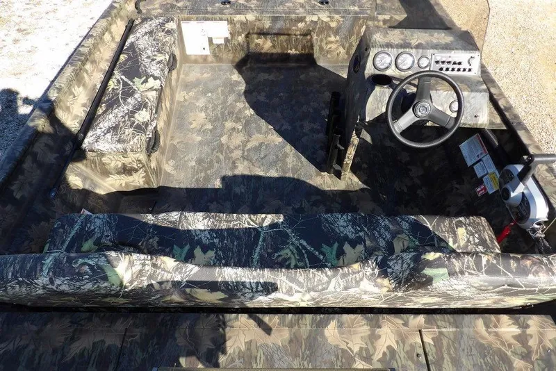 Slide: The Image of 2026 Crestliner 2070 Retriever SCHD boat interior with camouflage design and steering console. - 16