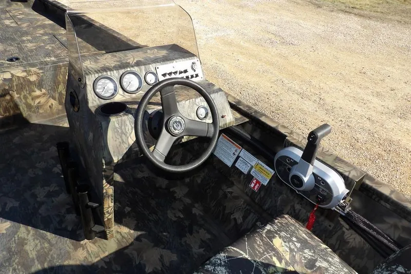 Slide: The Image of 2026 Crestliner 2070 Retriever SCHD boat dashboard with camo design and steering controls. - 22