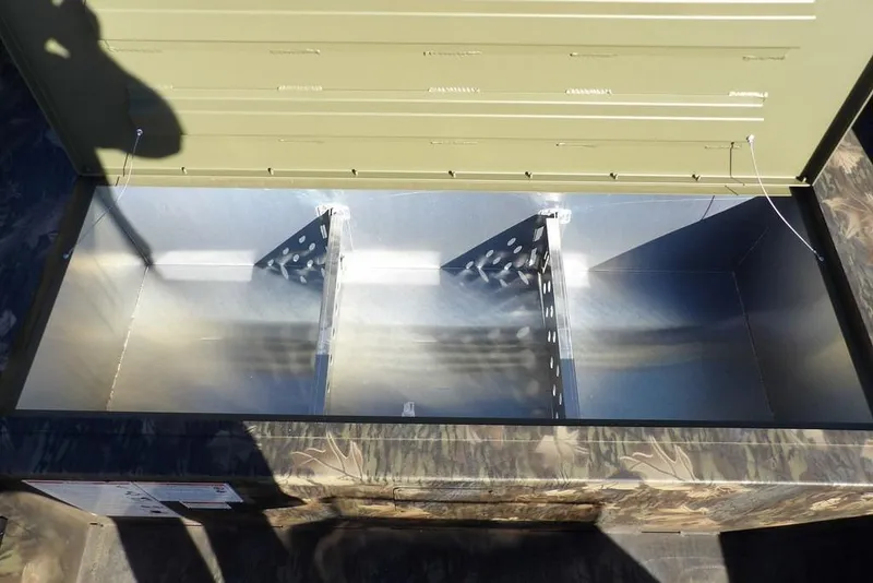 Slide: The Image of Open storage compartment in 2026 Crestliner 2070 Retriever SCHD boat, featuring metal dividers. - 27