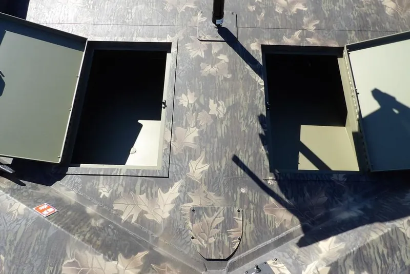 Slide: The Image of 2026 Crestliner 2070 Retriever SCHD boat with open storage compartments, camo pattern. - 35