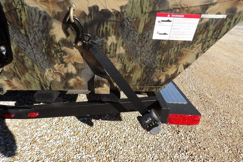 Slide: The Image of Crestliner 2070 Retriever SCHD 2026 boat with camouflage design and trailer on gravel. - 37