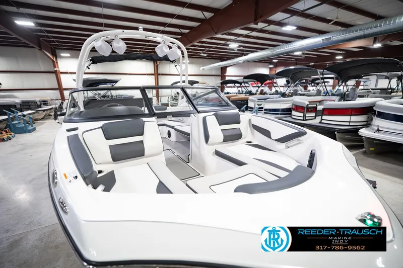Slide: The Image of 2024 Yamaha Boats AR195 in showroom, featuring sleek design and comfortable seating. - 13