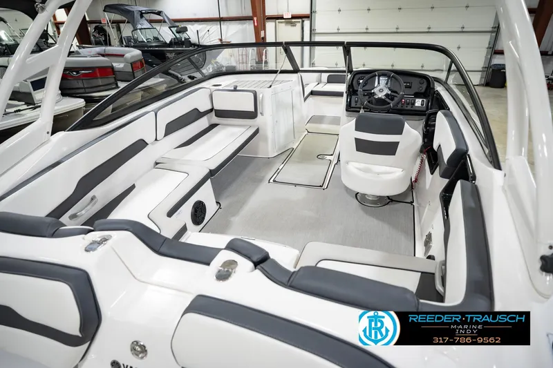 Slide: The Image of 2024 Yamaha Boats AR195 interior with sleek seating and modern dashboard in showroom. - 14