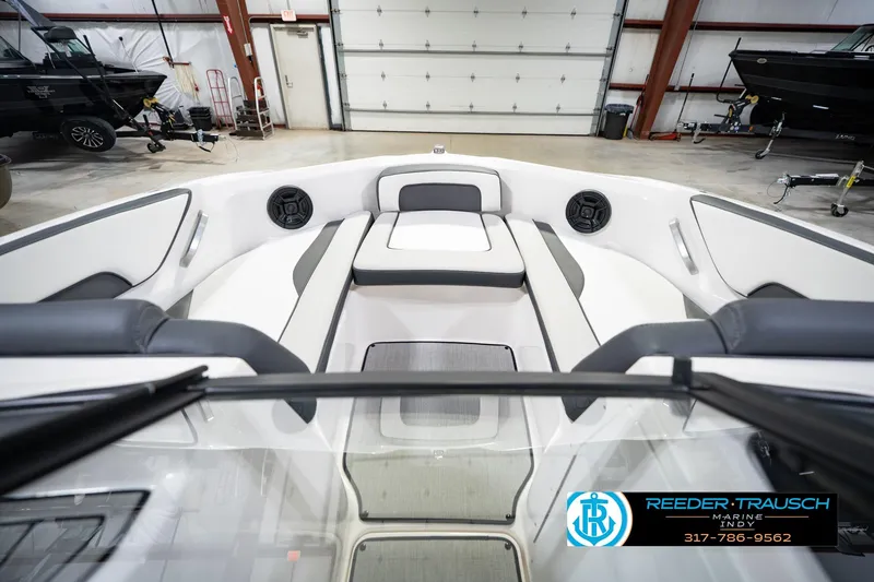 Slide: The Image of 2024 Yamaha Boats AR195 interior with sleek seating and modern design in a showroom. - 18