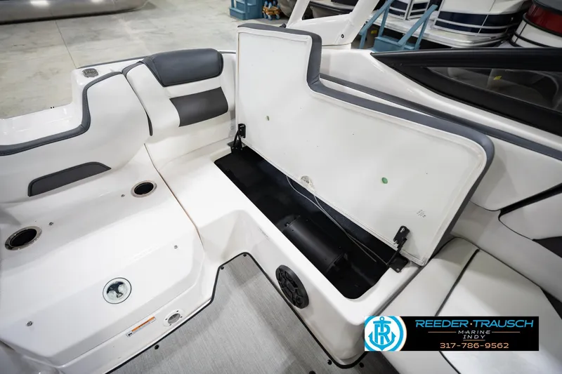 Slide: The Image of 2024 Yamaha Boats AR195 interior storage compartment with open hatch, showcasing sleek design. - 23