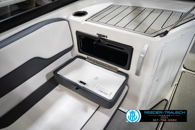 Slide: The Image of 2024 Yamaha AR195 boat interior storage compartment with sleek design and cup holder. - 27