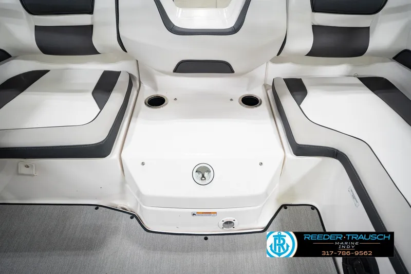 Slide: The Image of 2024 Yamaha AR195 boat interior with white and gray seating, cup holders, and logo. - 28