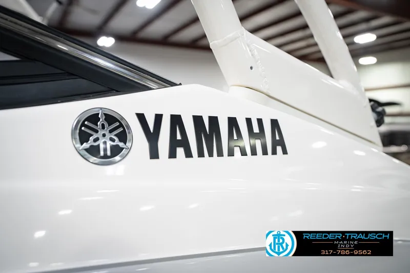 Slide: The Image of 2024 Yamaha AR195 boat close-up with logo in showroom setting. - 49