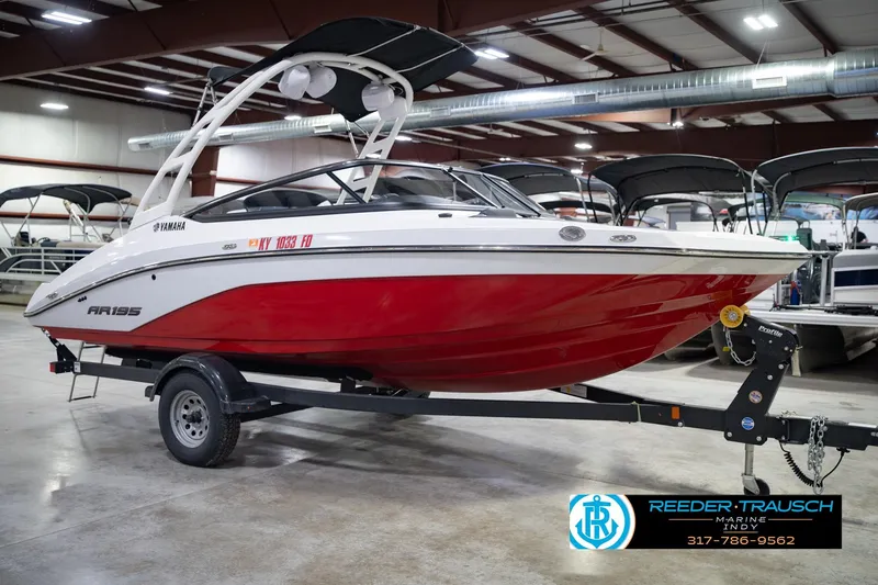 Slide: The Image of 2024 Yamaha AR195 boat with red hull on trailer in indoor showroom. - 6