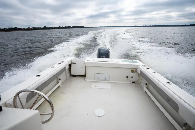 Slide: The Image of 2021 Parker 2520 XLD Sport Cabin boat cruising on open water, leaving a wake. - 11