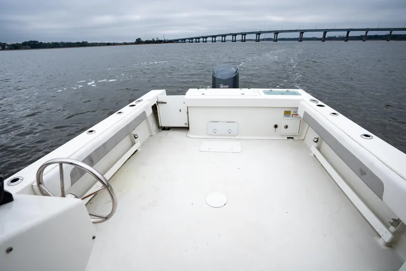 Slide: The Image of 2021 Parker 2520 XLD Sport Cabin boat on water, bridge in background. - 12