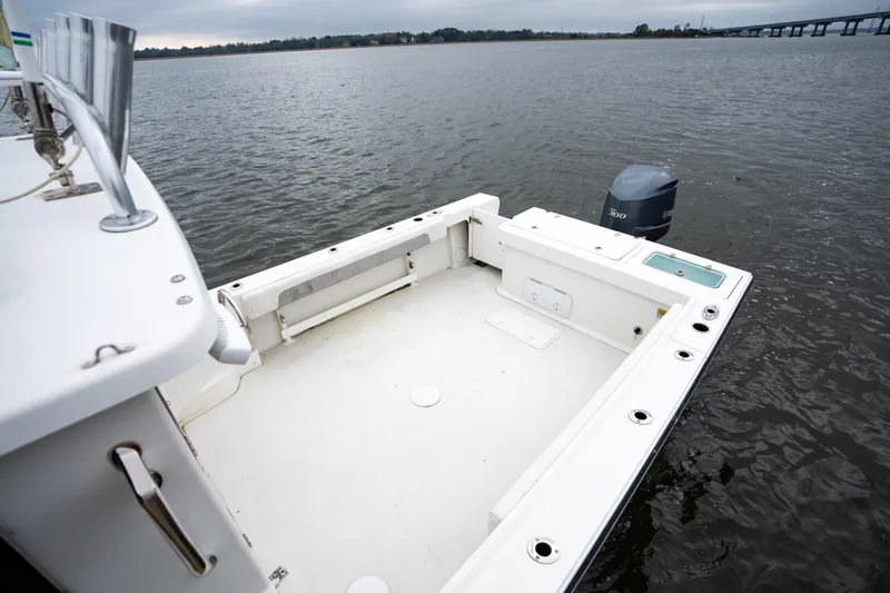 Slide: The Image of 2021 Parker 2520 XLD Sport Cabin boat with spacious deck and outboard motor on calm water. - 13