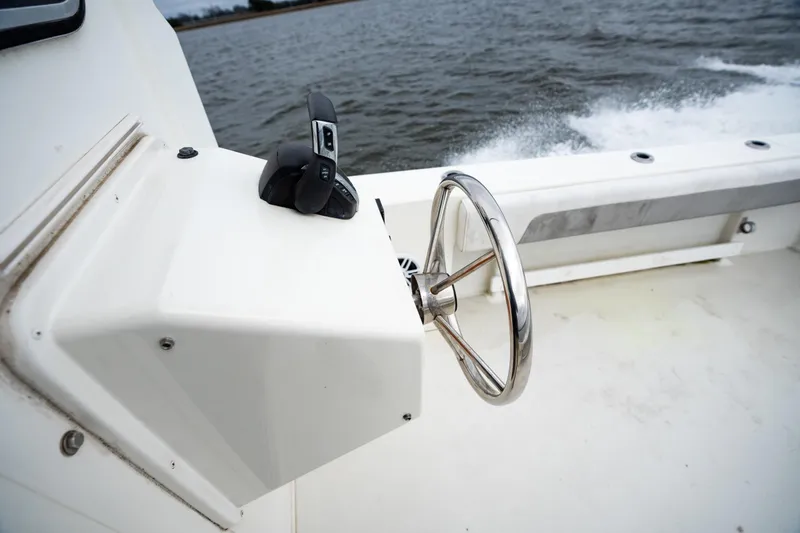 Slide: The Image of Steering wheel and controls of 2021 Parker 2520 XLD Sport Cabin boat on water. - 16