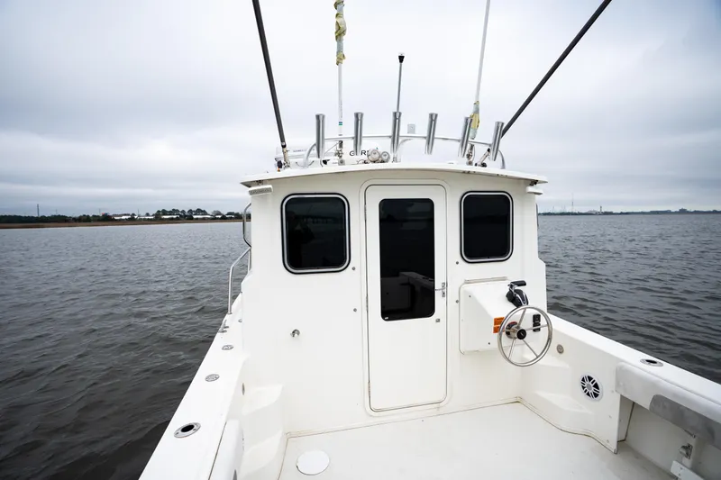 Slide: The Image of 2021 Parker 2520 XLD Sport Cabin boat on calm waters, showcasing rear cabin view. - 17