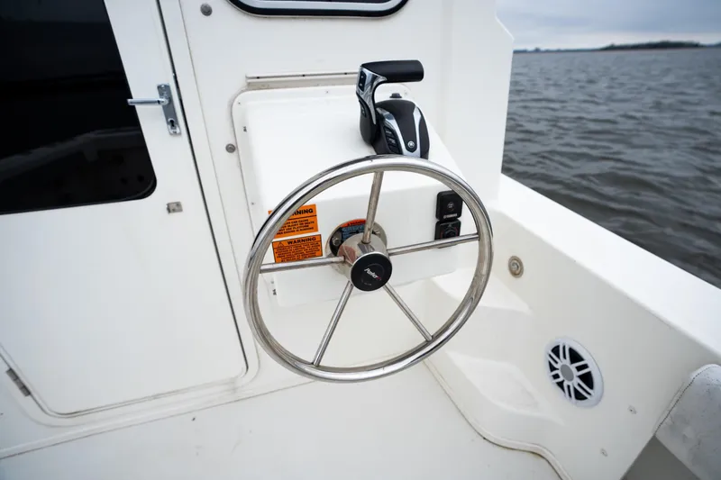 Slide: The Image of Steering wheel of 2021 Parker 2520 XLD Sport Cabin boat on water. - 20