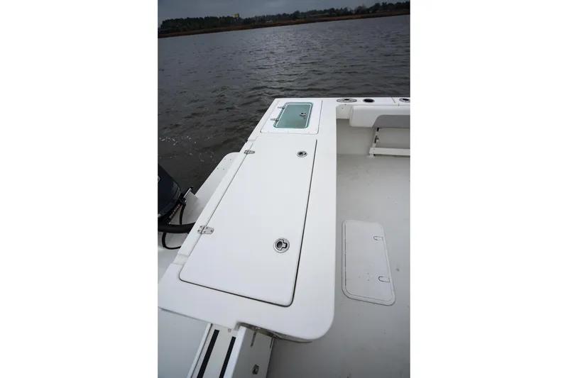 Slide: The Image of 2021 Parker 2520 XLD Sport Cabin boat deck with storage compartments, on calm water. - 24