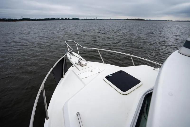 Slide: The Image of 2021 Parker 2520 XLD Sport Cabin boat on calm waters under cloudy skies. - 25