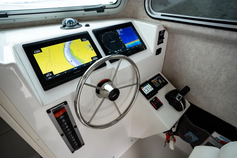 Slide: The Image of 2021 Parker 2520 XLD Sport Cabin helm with navigation displays and steering wheel. - 33