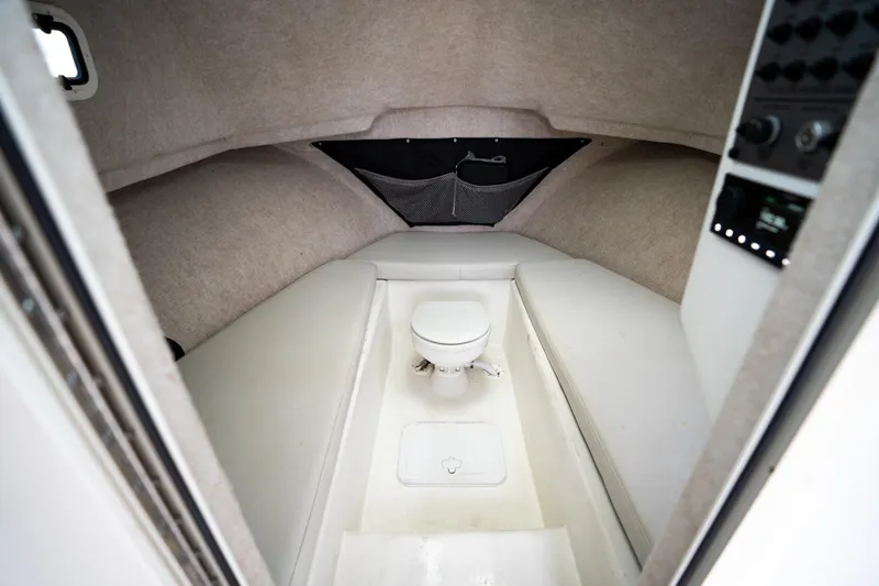 Slide: The Image of Interior cabin of 2021 Parker 2520 XLD Sport Cabin boat, featuring seating and a toilet. - 38