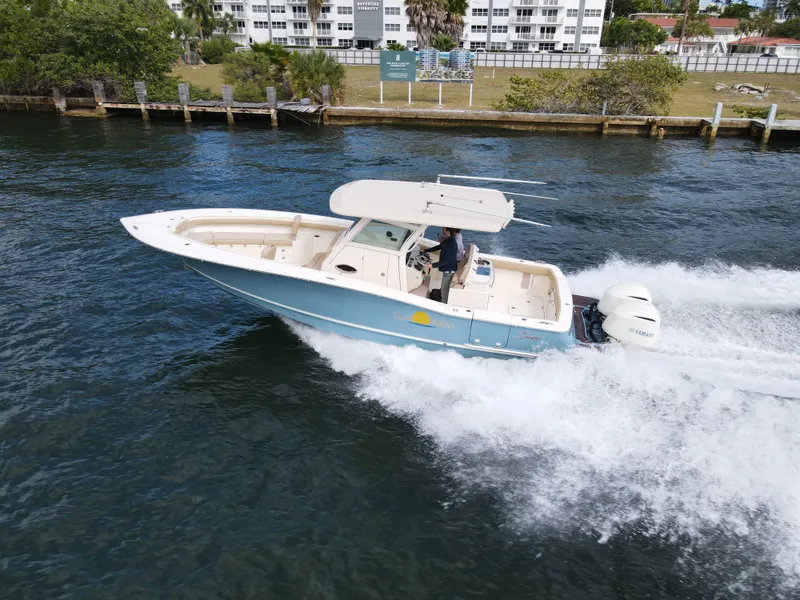Slide: The Image of 2017 Scout 320 LXF boat cruising on the water. - 2