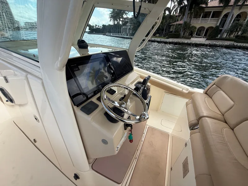 Slide: The Image of Interior view of a 2017 Scout 320 LXF boat by the water. - 4