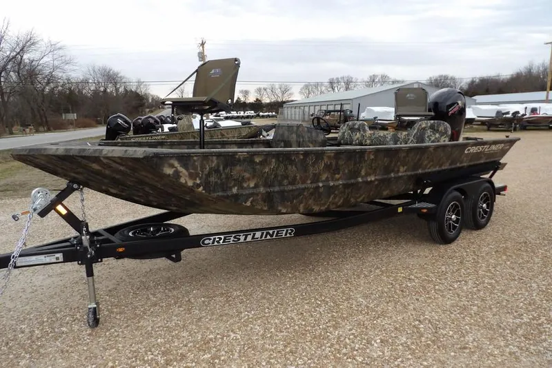 Slide: The Image of 2026 Crestliner 2070 Retriever SCHD boat on trailer, camo design, parked outdoors. - 3