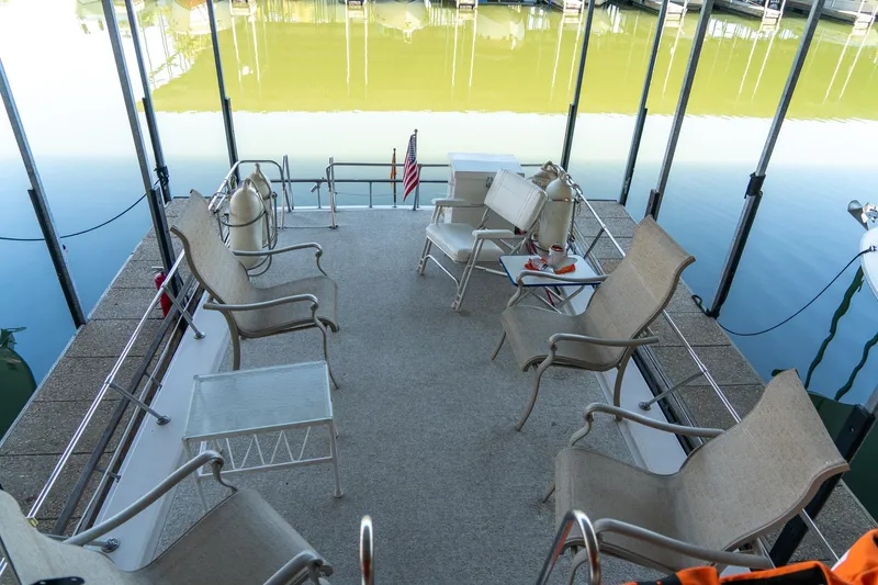 Slide: The Image of 1974 Boatel 47 Islander boat deck with chairs, table, and water view. - 10