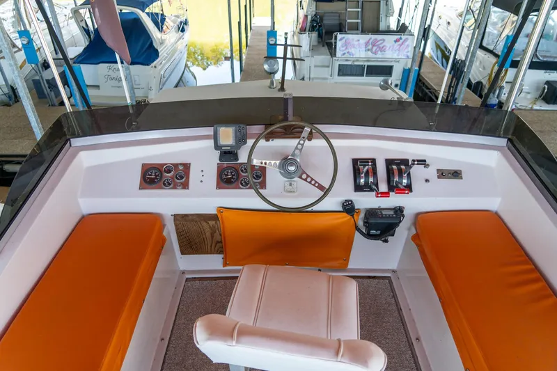 Slide: The Image of 1974 Boatel 47 Islander helm with orange seating, steering wheel, and control panel. - 13