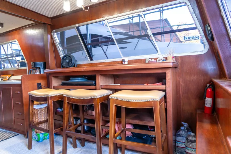 Slide: The Image of 1974 Boatel 47 Islander interior with wooden bar, stools, and large windows. - 16