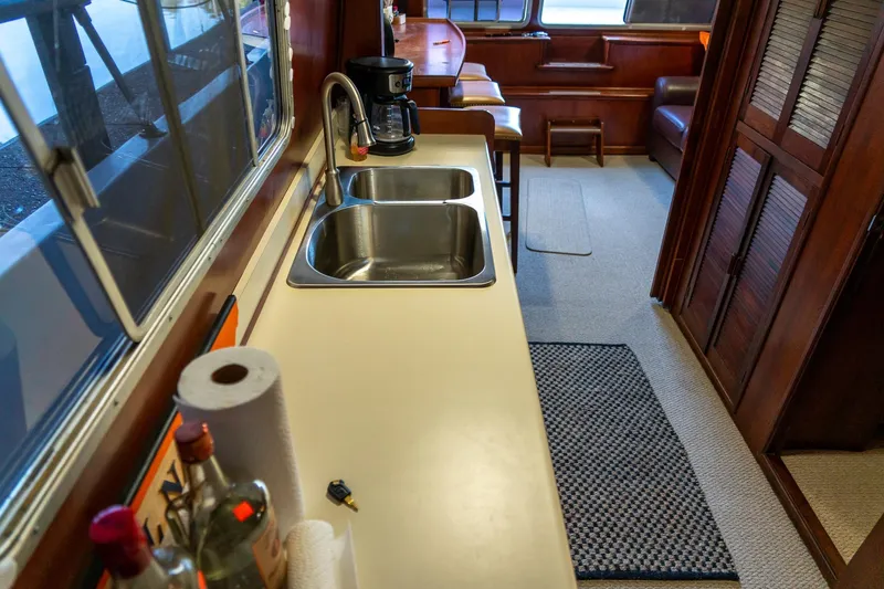 Slide: The Image of 1974 Boatel 47 Islander interior with kitchen sink, counter, and cozy seating area. - 20
