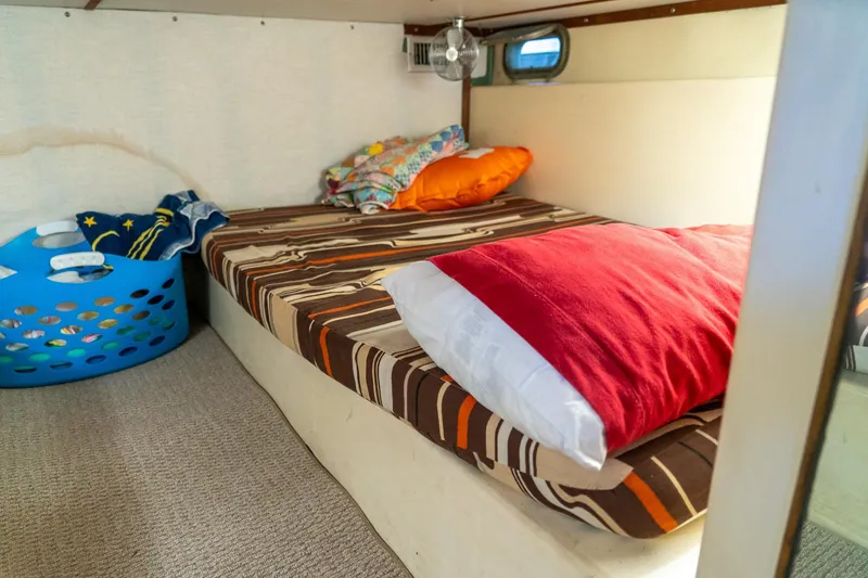 Slide: The Image of Cozy cabin interior of 1974 Boatel 47 Islander with striped bedding and colorful pillows. - 26