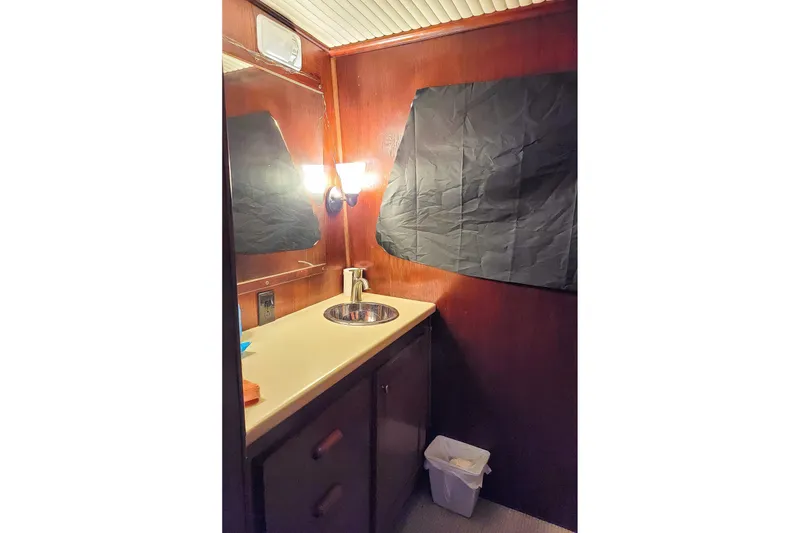 Slide: The Image of 1974 Boatel 47 Islander bathroom with wood paneling, sink, and mirror. - 27