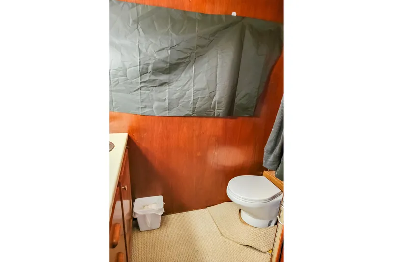 Slide: The Image of 1974 Boatel 47 Islander bathroom with wooden paneling and compact toilet. - 28