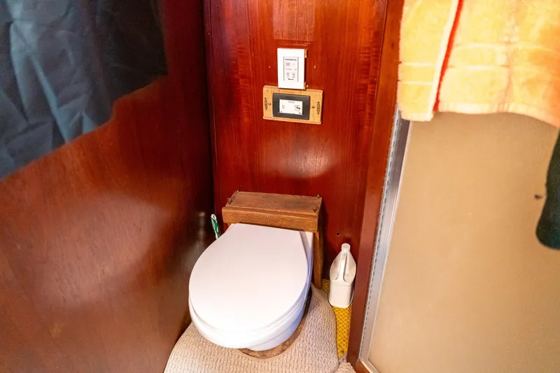 Slide: The Image of 1974 Boatel 47 Islander bathroom with wooden paneling and compact toilet. - 29