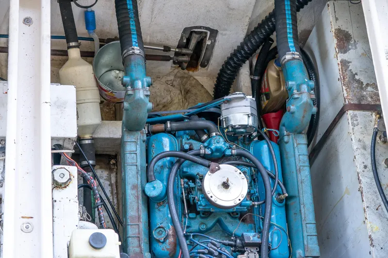 Slide: The Image of 1974 Boatel 47 Islander engine compartment with visible blue engine and components. - 33