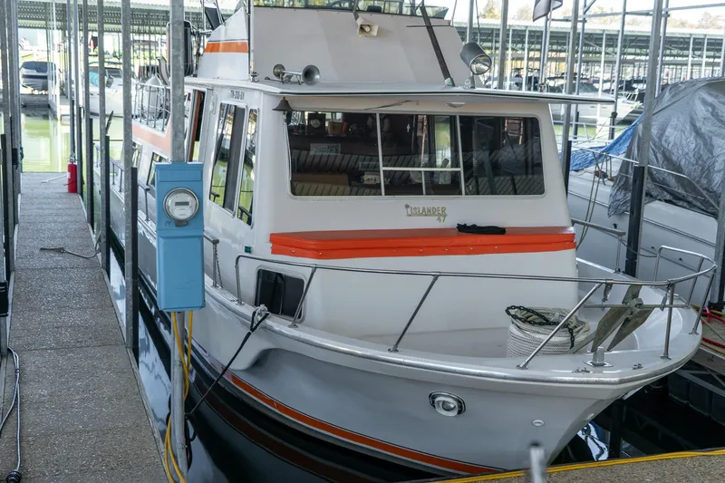 Slide: The Image of 1974 Boatel 47 Islander docked in marina, featuring classic design and orange accents. - 6