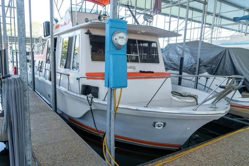 Slide: The Image of 1974 Boatel 47 Islander docked in a marina, featuring classic design and vibrant accents. - 7