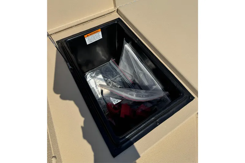 Slide: The Image of Open storage compartment on 2026 G3 Bay 17 boat, containing plastic bags and accessories. - 6