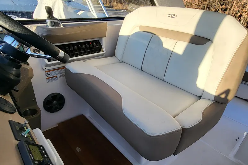 Slide: The Image of Captain's seat in 2018 Regal 35 Sport Coupe boat cockpit, featuring control panel and steering wheel. - 15