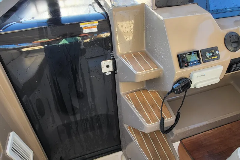 Slide: The Image of 2018 Regal 35 Sport Coupe cockpit with steps, control panel, and Garmin device. - 16