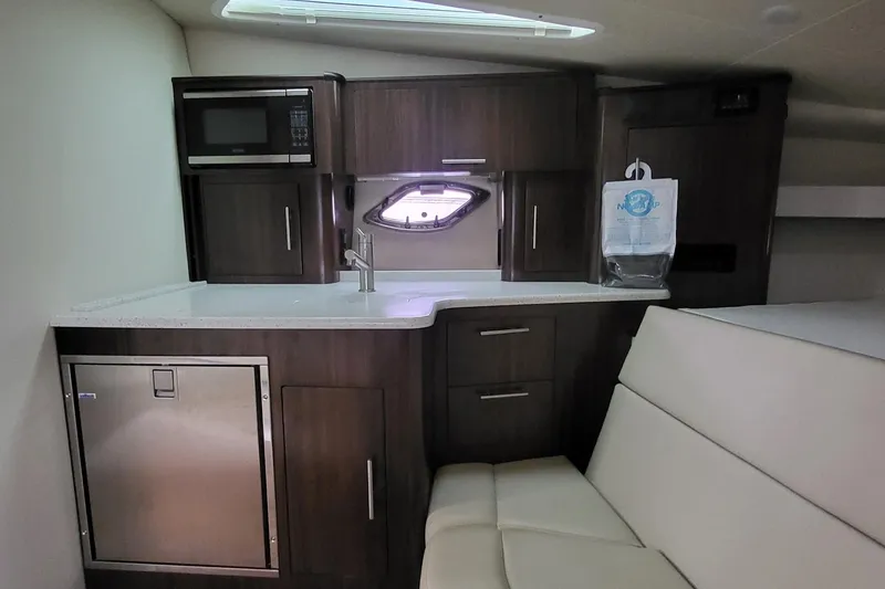 Slide: The Image of 2018 Regal 35 Sport Coupe interior kitchen with microwave, sink, and seating area. - 27