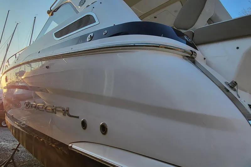Slide: The Image of 2018 Regal 35 Sport Coupe boat, sleek design, docked at sunset. - 6
