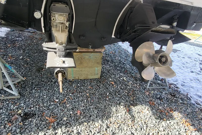 Slide: The Image of 2018 Regal 35 Sport Coupe boat propeller and drive system on gravel. - 7