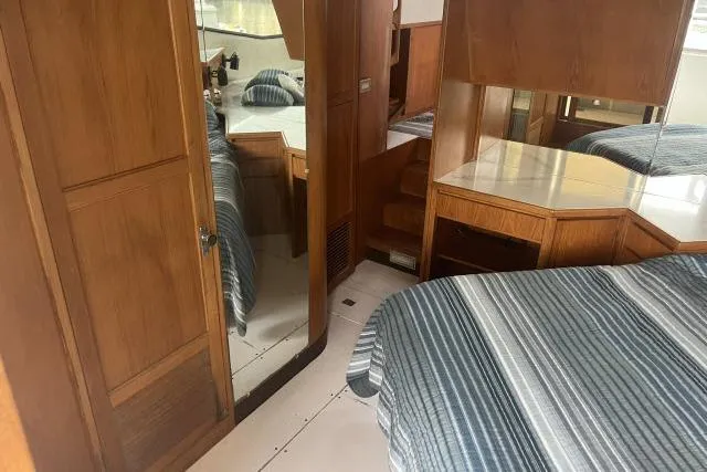 Slide: The Image of 1988 Kadey Krogen 42 yacht interior with wood paneling and striped bedding. - 10