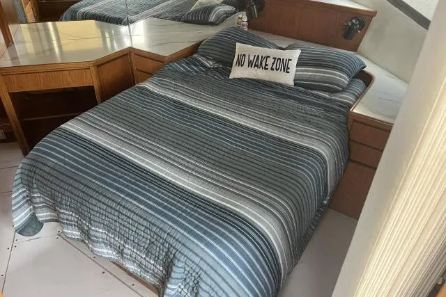 Slide: The Image of Cozy bedroom in 1988 Kadey Krogen 42 boat with striped bedding and "No Wake Zone" pillow. - 11