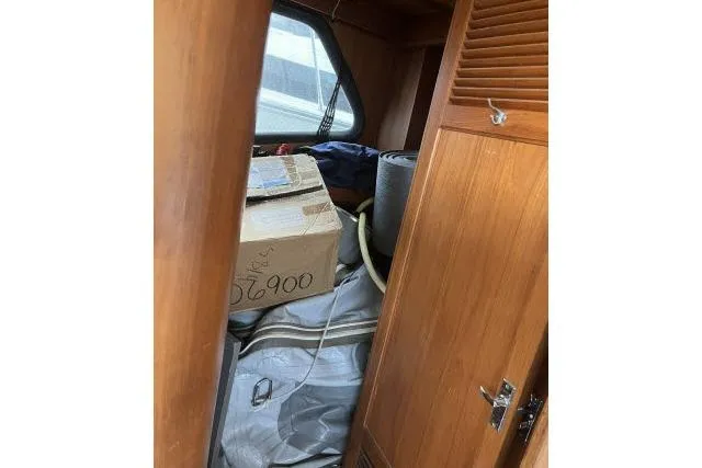 Slide: The Image of 1988 Kadey Krogen 42 interior storage with cardboard box and rolled items. - 13